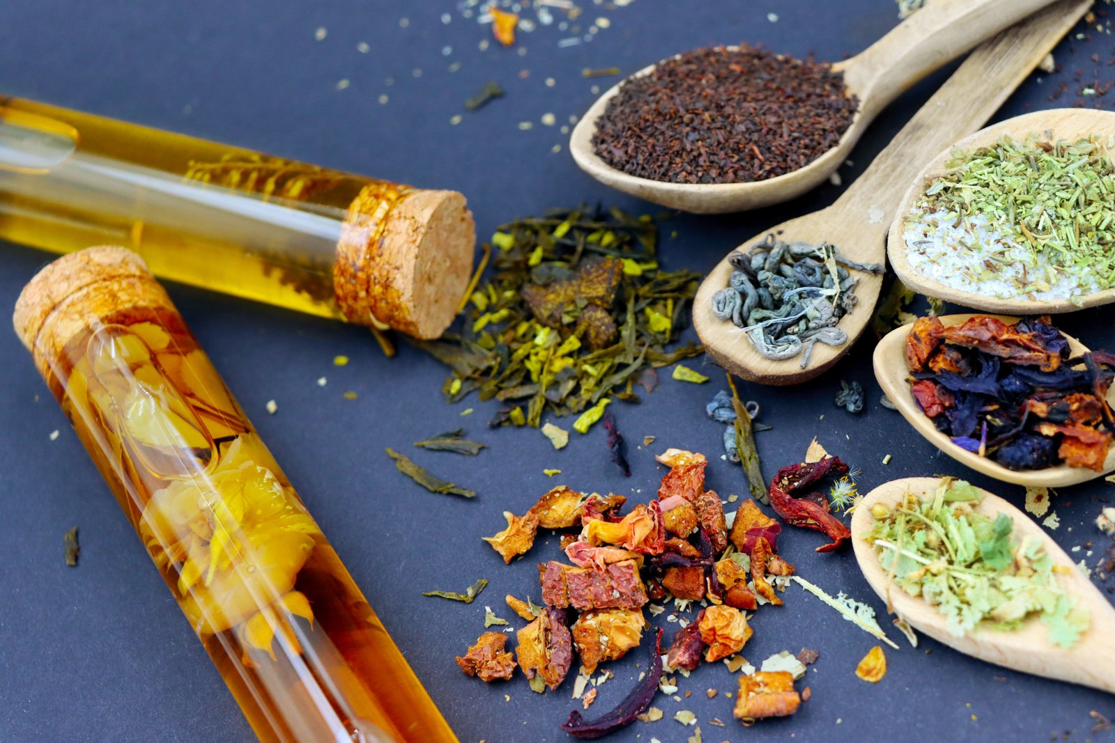 Flat lay of tea leaves, berries, lemons, ginger and fresh herbs